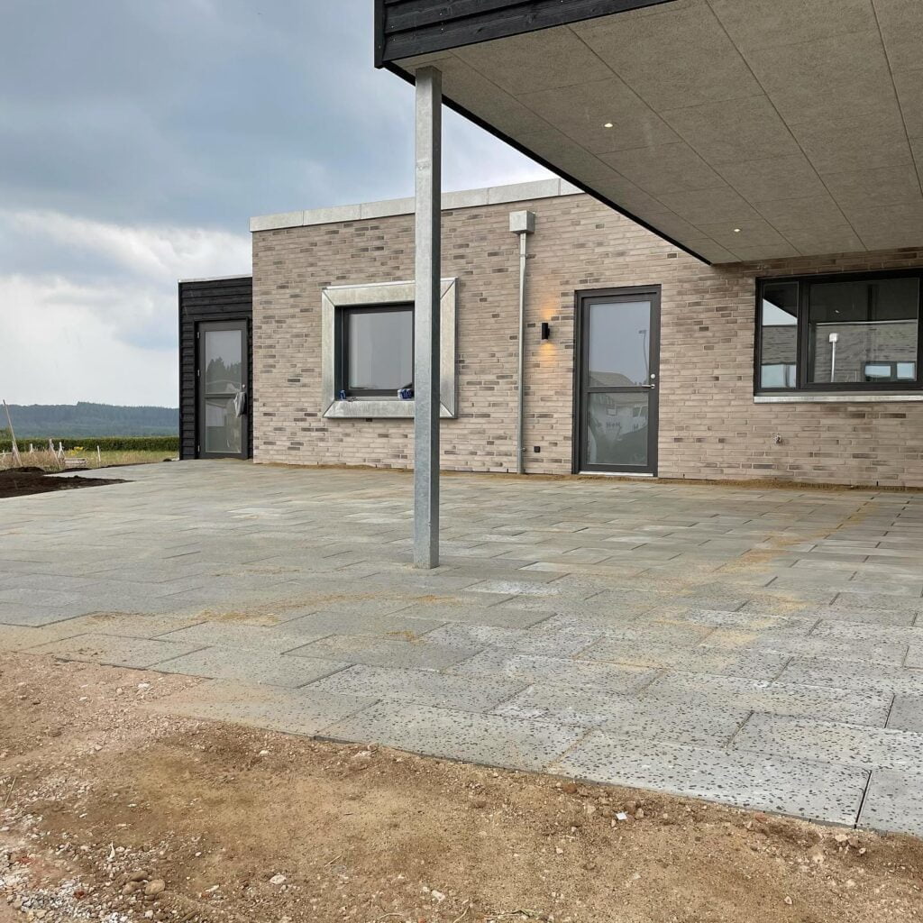 Ny flisebelægning foran moderne hus