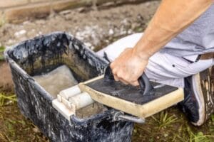 Hånd vasker flisesvamp i spand med vand